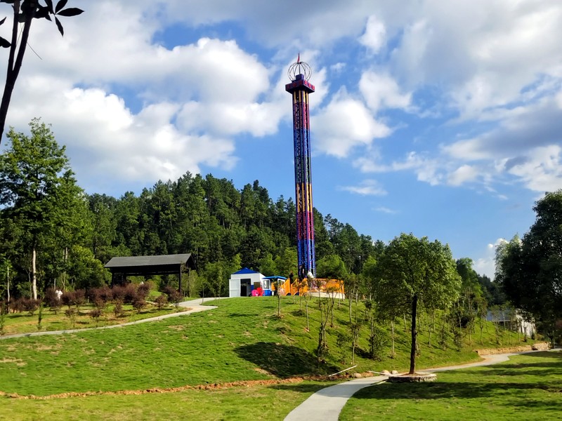 Drop tower ride seen above the surrounding amusement park